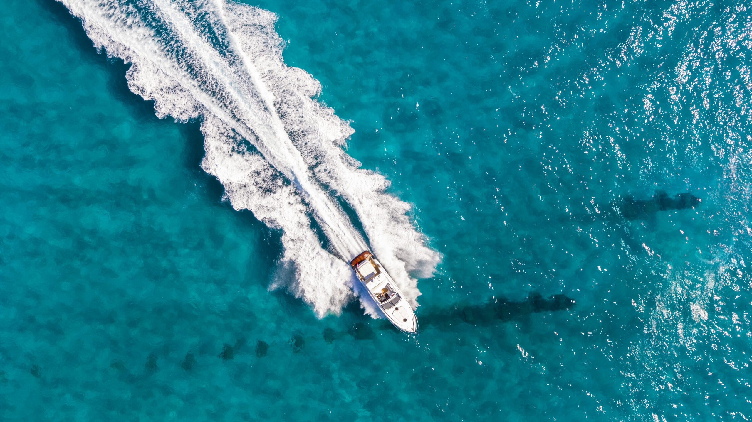 RF Bank & Trust - Aerial view of yacht cruising over turquoise water